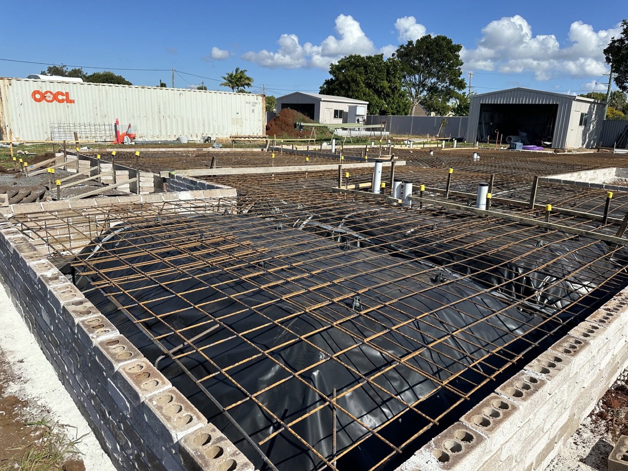 Reinforcing mesh tied over plastic membrane inside formwork, ready for a slab pour
