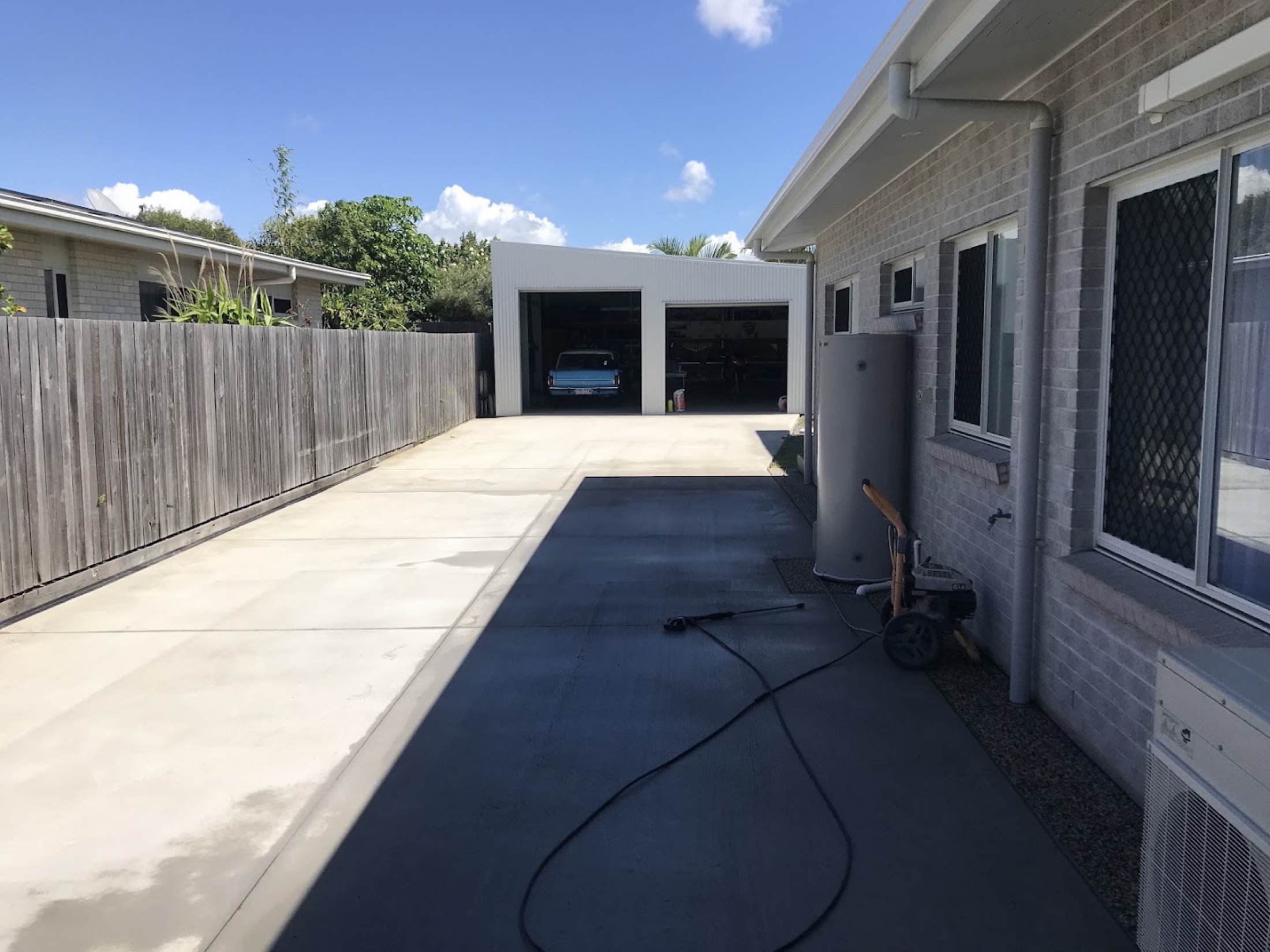 A concrete driveway running alongside a carport at a Bundaberg home