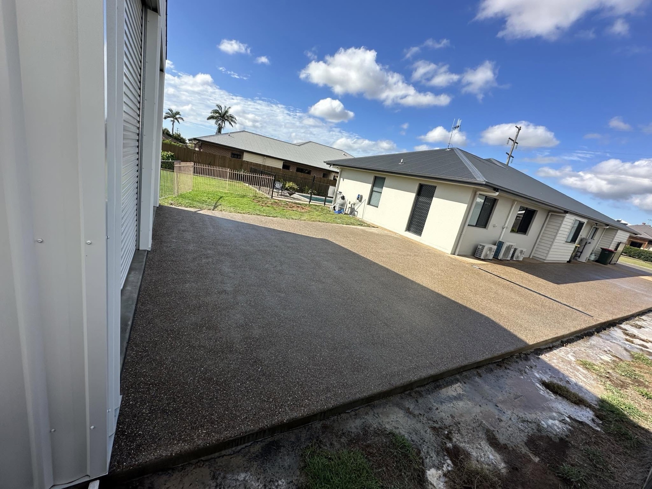 An exposed aggregate driveway running along the side of a house to the street