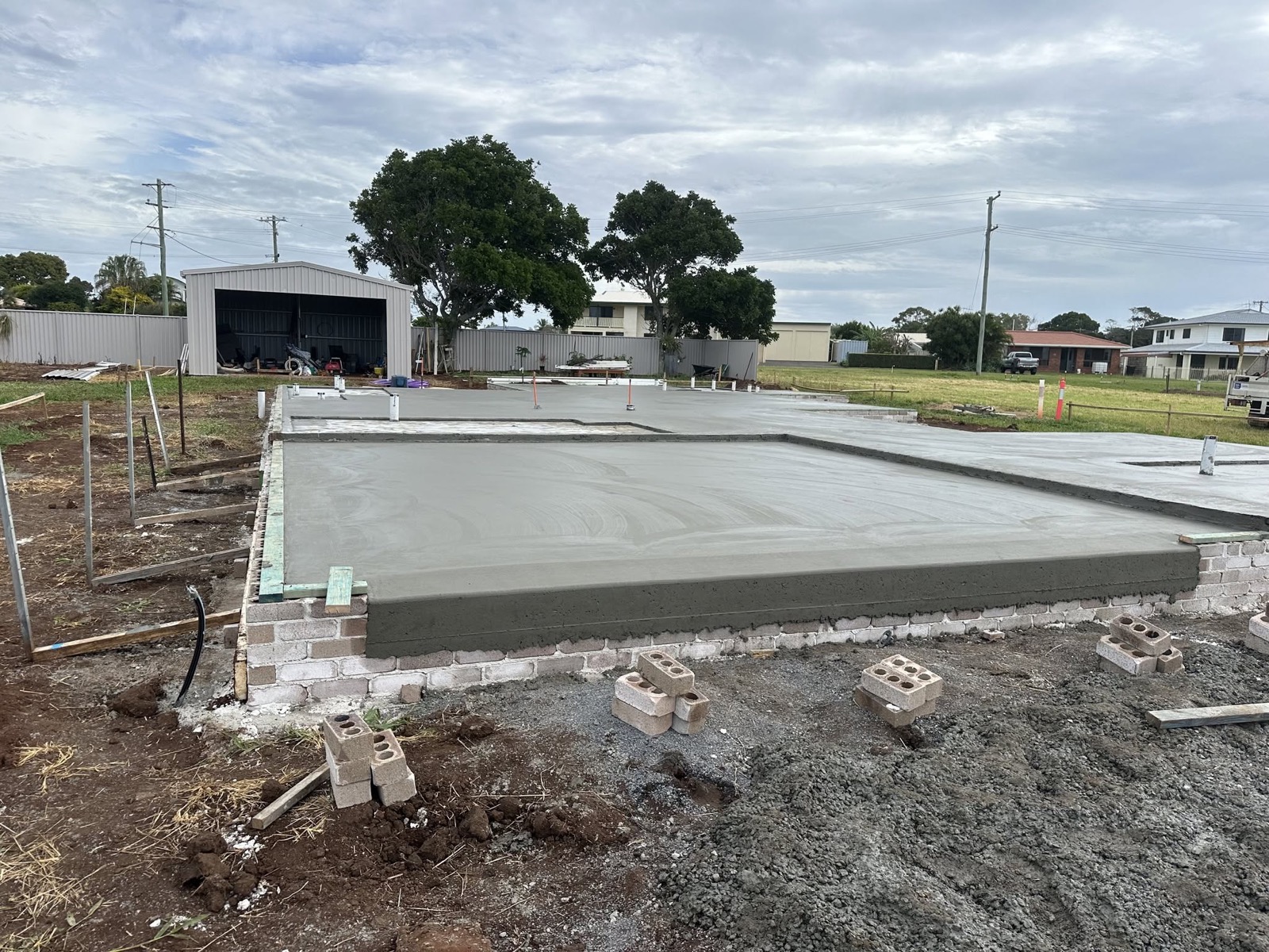 A poured house slab still in its formwork on a cleared block