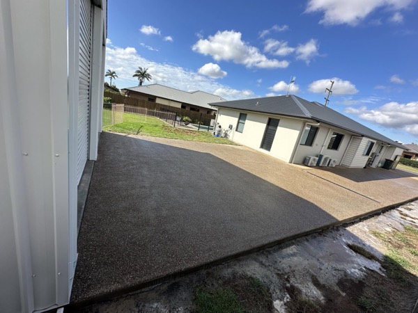 An exposed aggregate driveway running along the side of a house