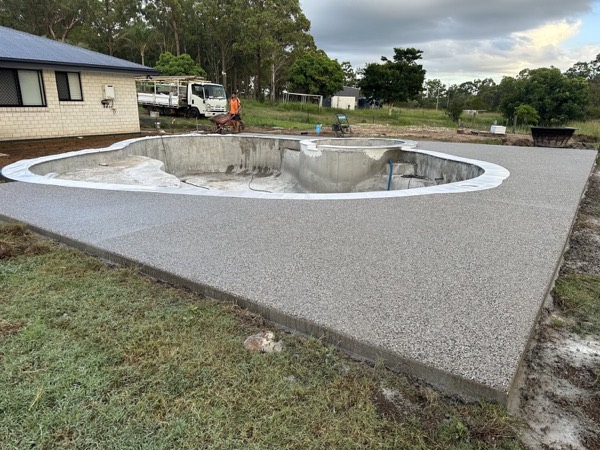 A wide exposed aggregate surround around a freeform pool