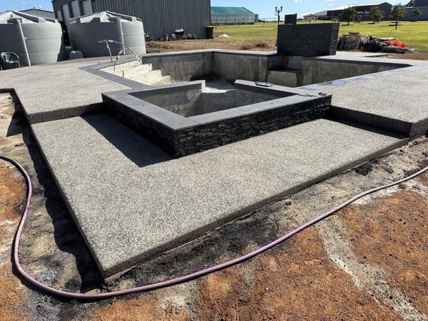 A raised concrete plinth and exposed aggregate deck at a rural property