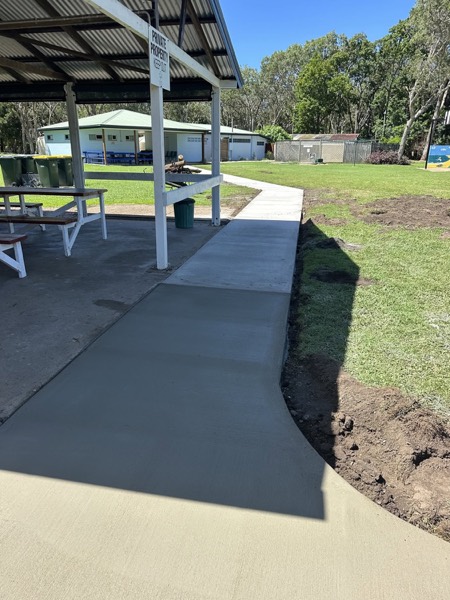 A new concrete path and pad beside a picnic shelter