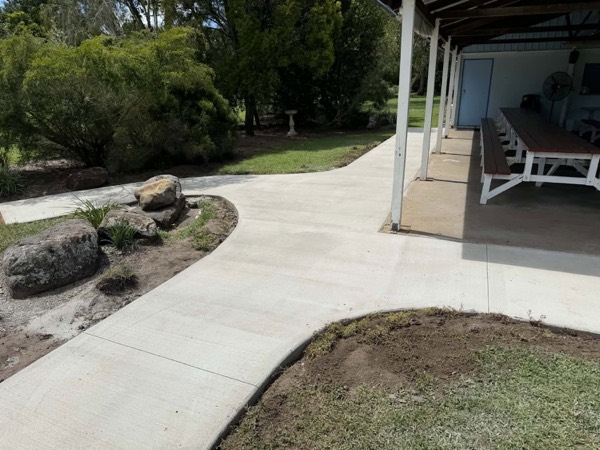 A curved concrete path running past a landscaped garden bed