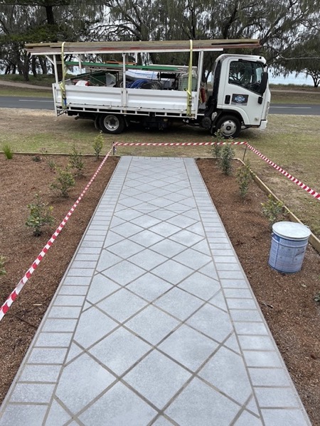 The business truck parked behind a newly laid patterned concrete path