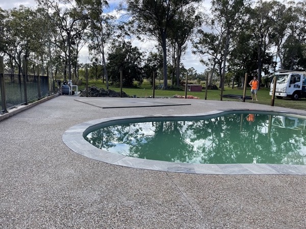 A freeform pool with an exposed aggregate surround