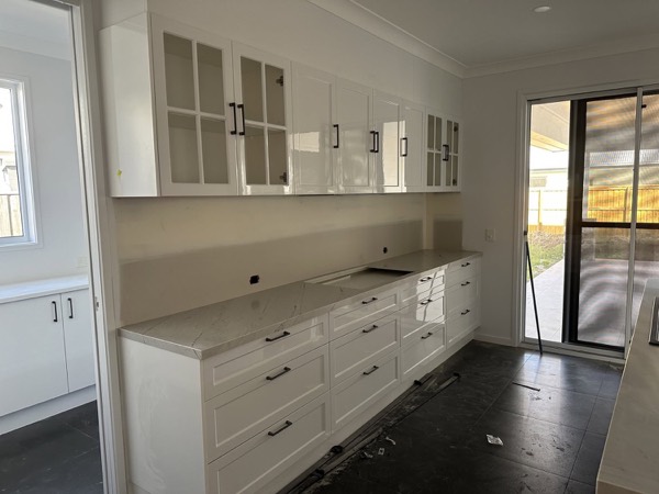 A long run of white kitchen cabinetry with deep drawers