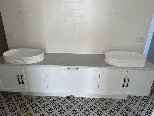 A built-in window seat with white cabinetry underneath